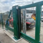 Metal mesh sliding gate with tracked support system installed at an industrial site entrance