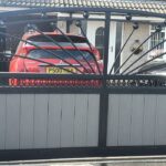 Bespoke composite driveway gate with decorative steel sunburst design