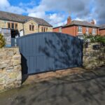 Modern arch top composite driveway gate in dark grey, offering durability and style