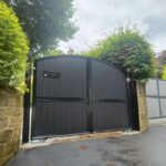 Contemporary black arch top composite driveway gate with strong frame and secure design