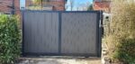 Flat top composite sliding gate installed at a residential driveway entrance