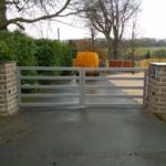 Custom driveway gate featuring a minimalist horizontal bar design for a modern entrance