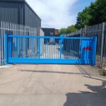 Metal vertical-bar sliding gate installed at an industrial site entrance