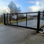 Metal mesh sliding gate installed at an industrial site entrance