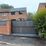 Flat top composite driveway gate with vertical composite boards and metal frame